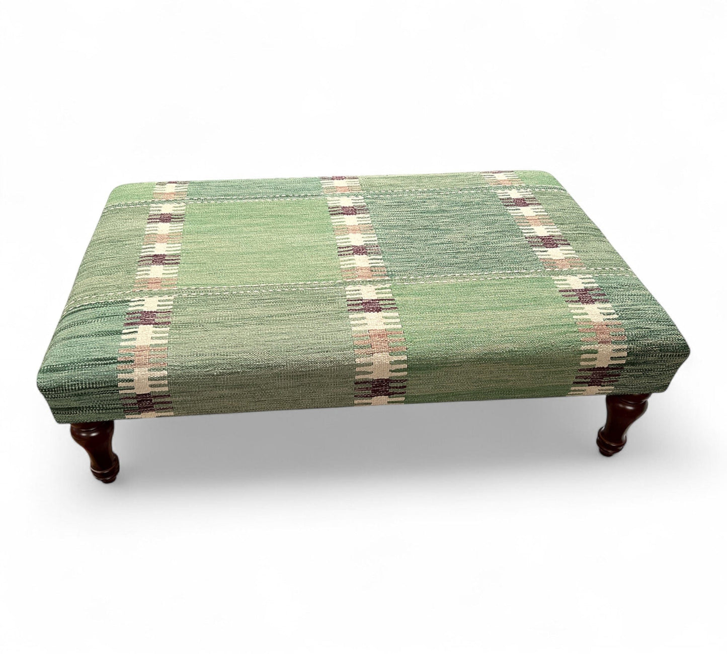 Green patterned kilim ottoman on a white background