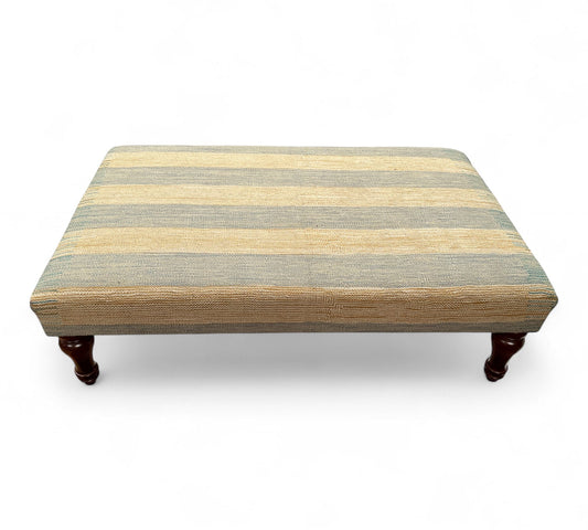 Striped ottoman with wooden legs on a white background
