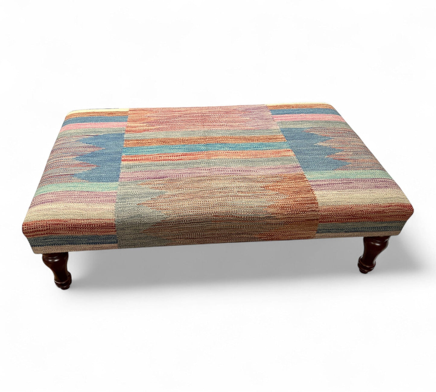 Multicolored patterned kilim ottoman on a white background