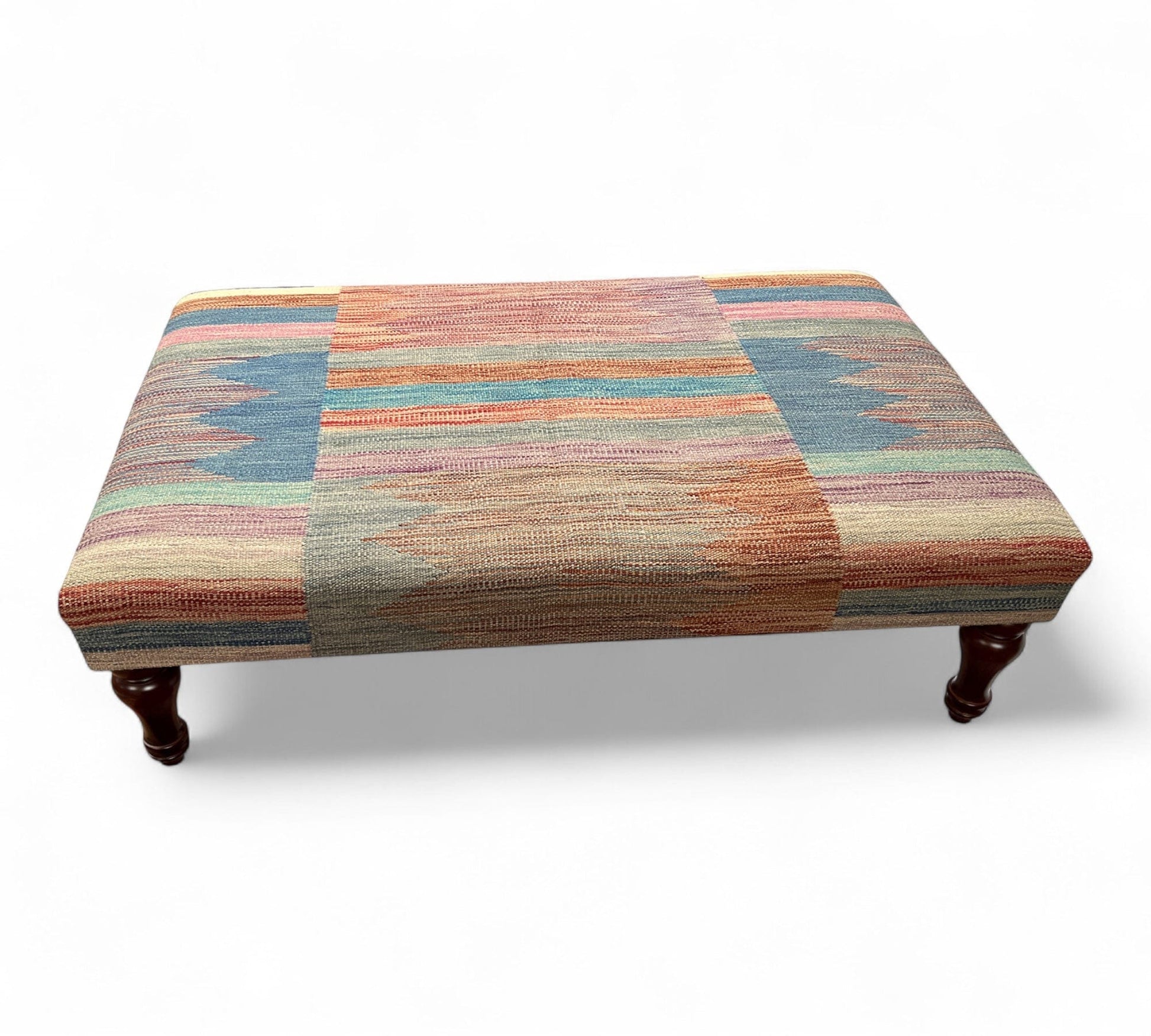 Multicolored patterned kilim ottoman on a white background