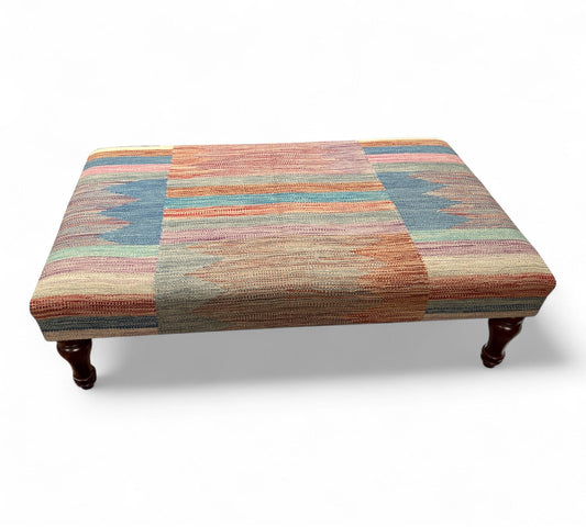 Multicolored patterned kilim ottoman on a white background